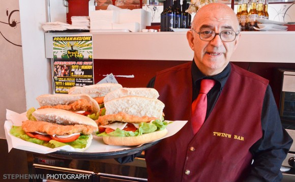 Italian waiter carrying tray of subs