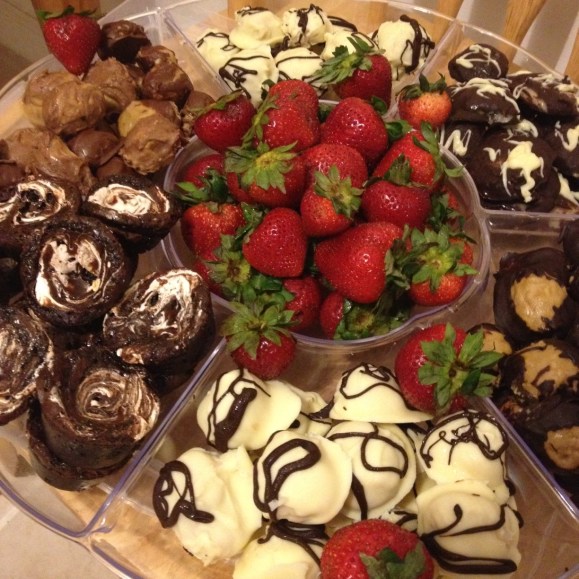 Clockwise from top, we've got white-chocolate- and dark-chocolate-covered no-bake cake truffles, dark-chocolate buckeyes, more truffles, marshmallow-swirl brownie bites, and milk-chocolate buckeyes. And you probably recognize the berries.