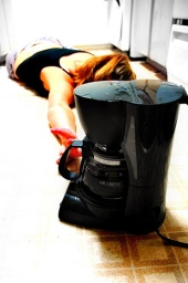 tired girl on kitchen floor with coffee maker